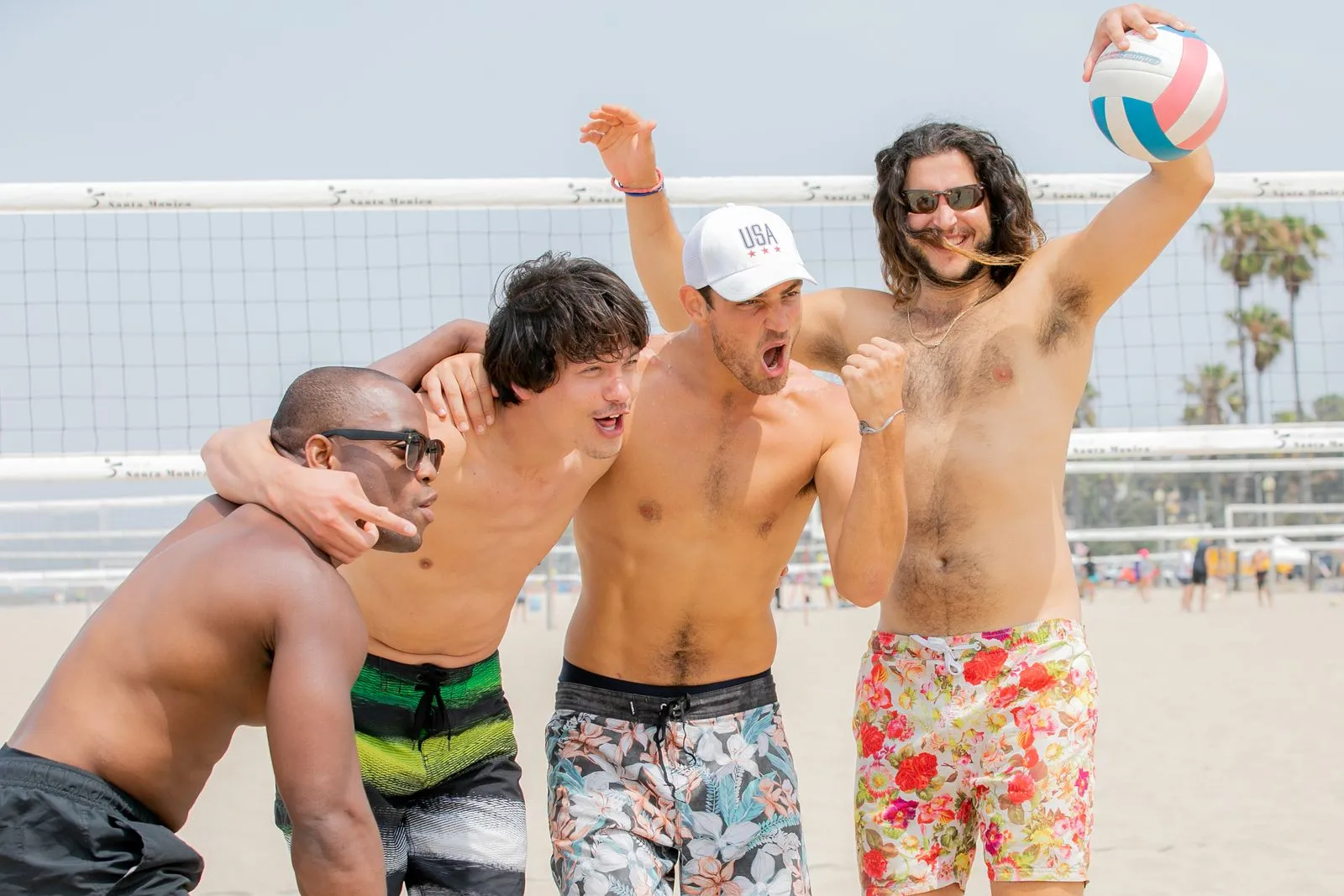 Gruppo di amici che festeggia a rete dopo la prima partita di beach volley